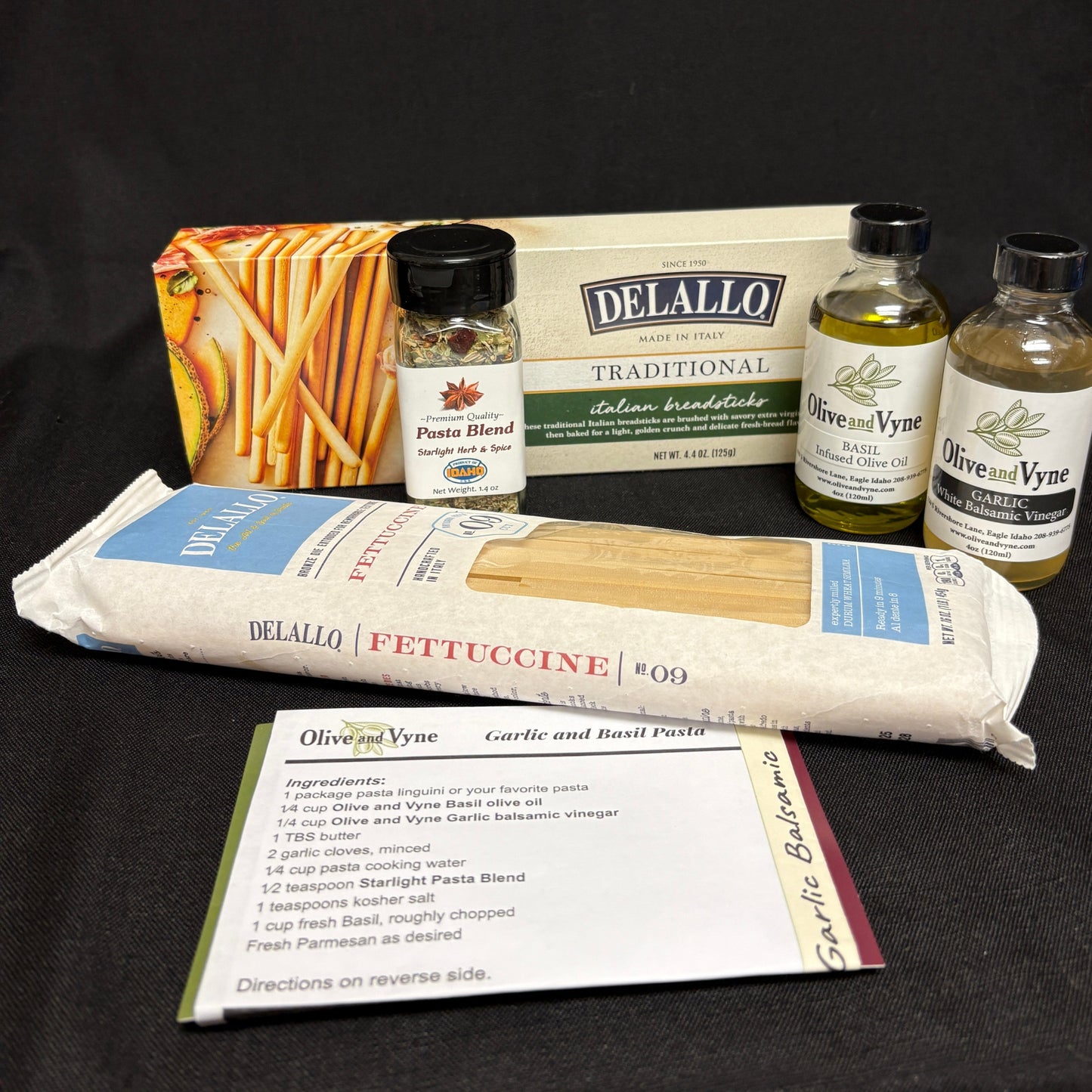 Garlic and Basil Infused Olive Oils, Starlight Pasta Blend, DeLallo fettuccine, Italian breadsticks, and printed pasta recipe card.