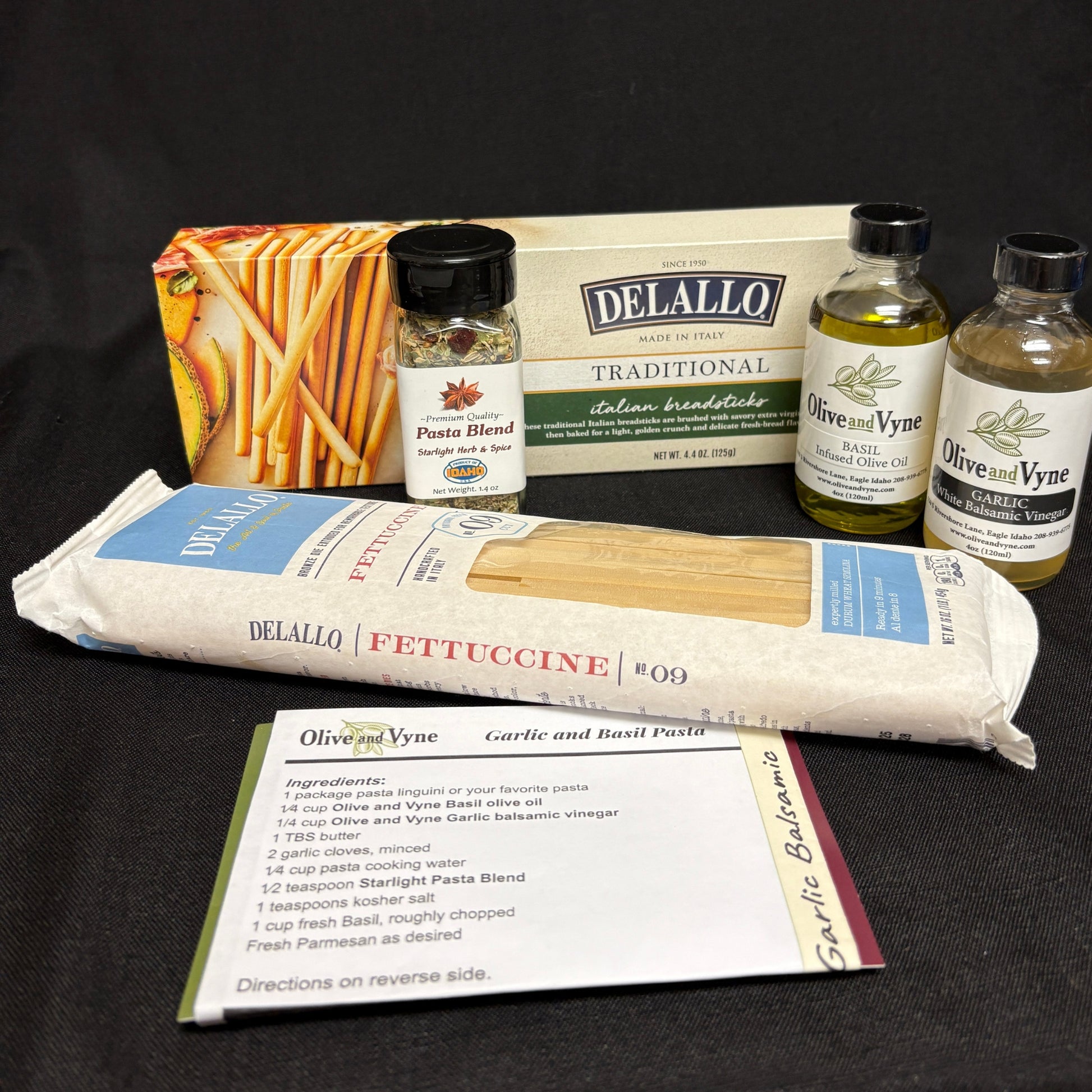 Garlic and Basil Infused Olive Oils, Starlight Pasta Blend, DeLallo fettuccine, Italian breadsticks, and printed pasta recipe card.