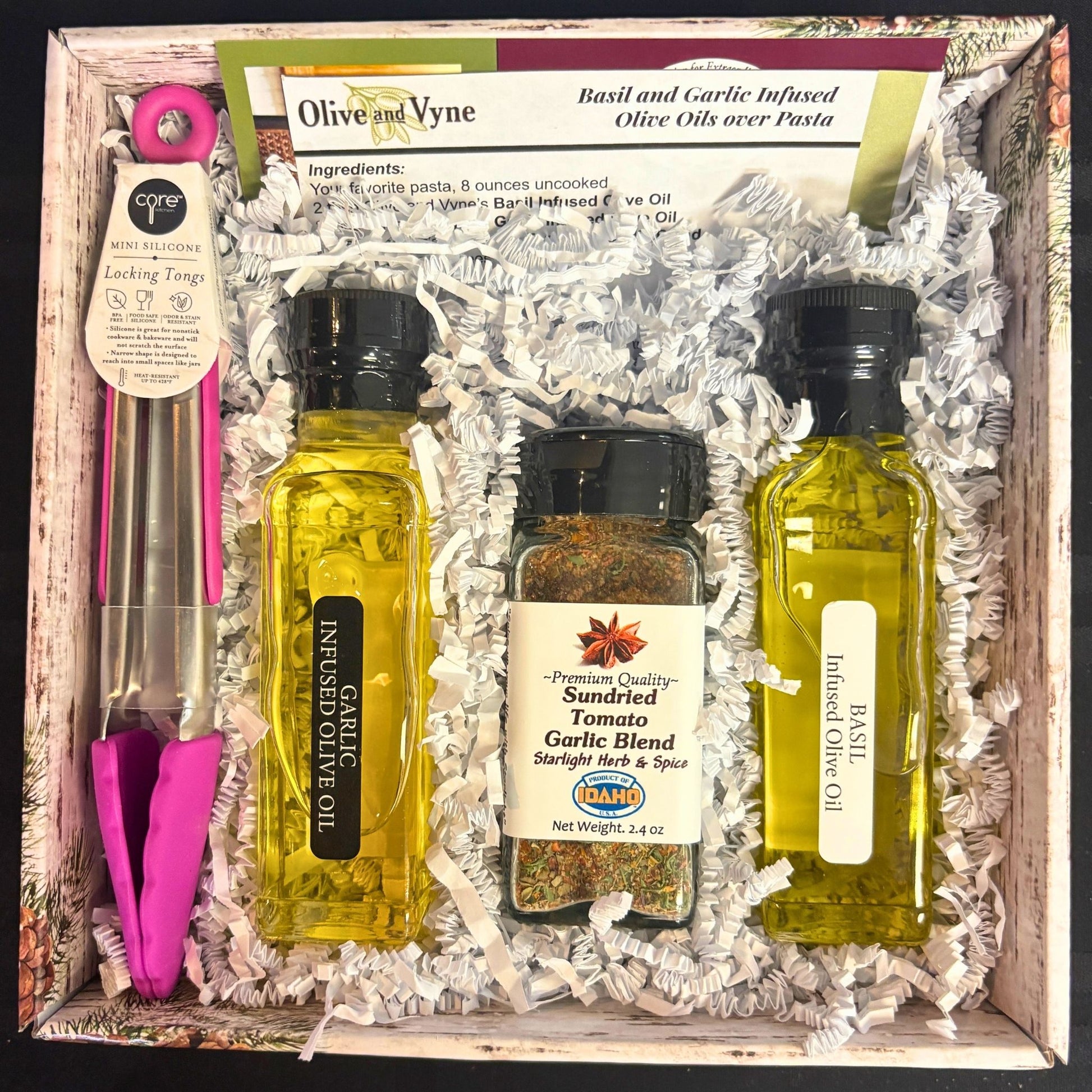 Open Basil & Garlic pasta gift set showing Garlic EVOO, Basil EVOO, seasoning, tongs, and recipe card