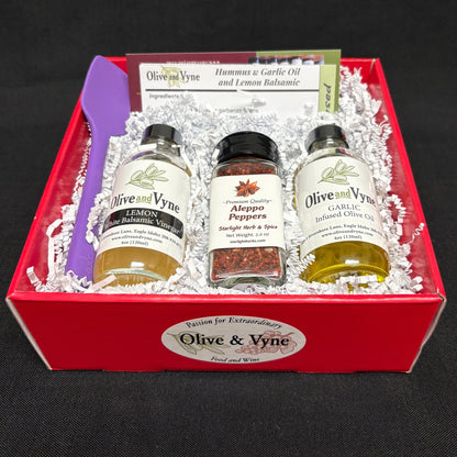 Open hummus gift box with Garlic Infused Olive Oil, Lemon White Balsamic, Aleppo Pepper, spatula, and recipe card.