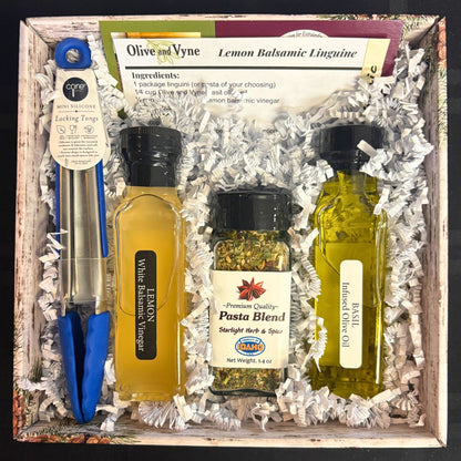 Open Lemon Balsamic pasta gift set showing Basil EVOO, Lemon White Balsamic, Pasta Blend seasoning, and tongs